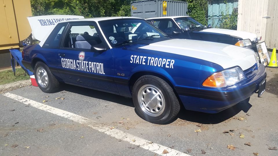Blue and white Ford Mustang with 'Georgia State Patrol' and 'State Trooper' text, 5.0 badge visible