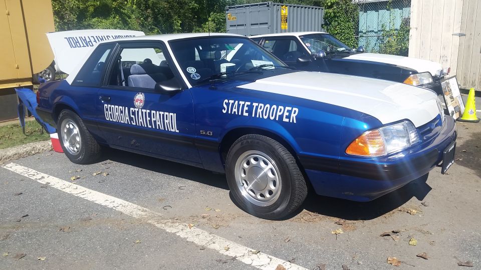 Blue and white Ford Mustang GT police car with 'Georgia State Patrol' and 'State Trooper' text