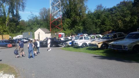 1991 Ford LTD Crown Victoria - A collection of vintage police vehicles are displayed outdoors on a sunny day.