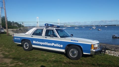1991 Ford LTD Crown Victoria - Metropolitan Police Crown Victoria parked by the water with a bridge in the distance.