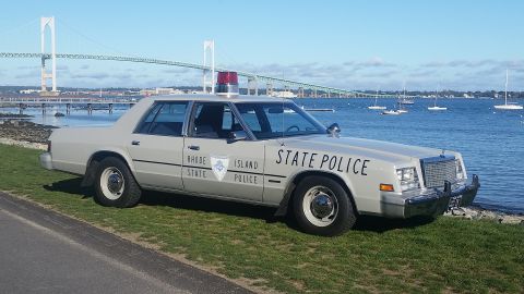 1991 Ford LTD Crown Victoria - Rhode Island State Police car parked near a bridge and bay.