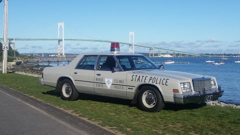 1991 Ford LTD Crown Victoria - This police car has 'Rhode Island State Police' written on its side and a light bar on top.