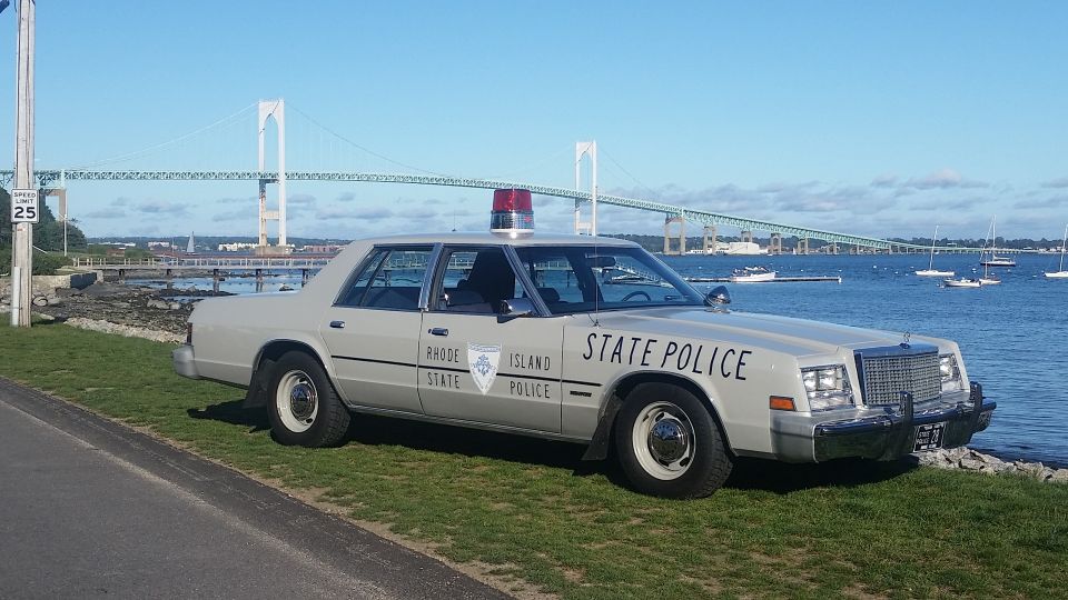 Rhode Island State Police car parked by the water with a bridge in the background