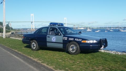 1991 Ford LTD Crown Victoria - A 1991 Ford Crown Victoria police car is parked by the water with a bridge in the background.