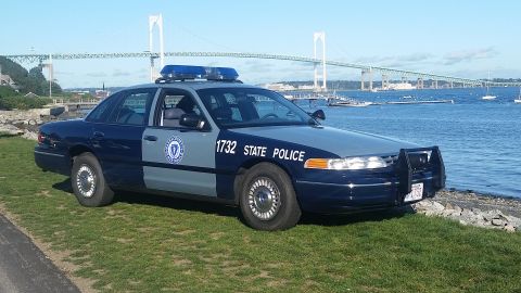 1991 Ford LTD Crown Victoria - A 1991 Ford Crown Victoria police car is parked near the water with a bridge in the distance.