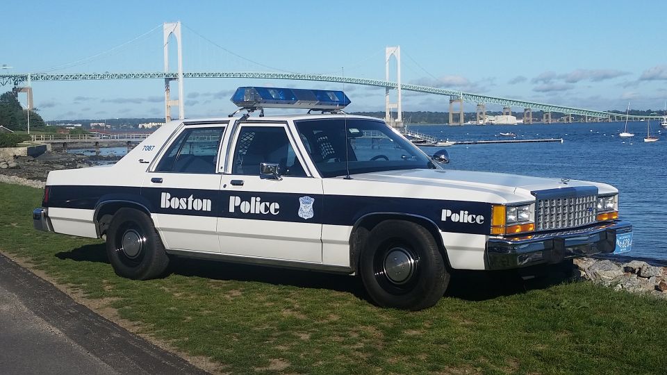 Boston Police car parked by the water with a bridge in the background. It's a 1991 Ford Crown Victoria