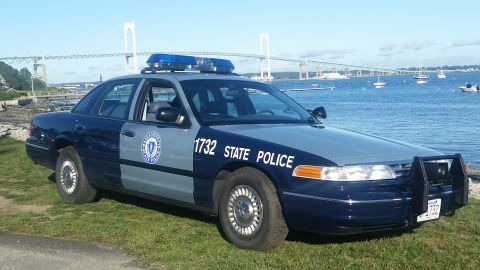 1991 Ford LTD Crown Victoria - A police car with "STATE POLICE" text on its side is parked by the water.