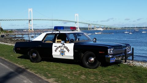 1991 Ford LTD Crown Victoria - This police car is parked near the water with a bridge in the background.