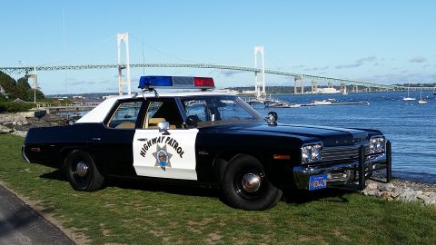 1991 Ford LTD Crown Victoria - This 1977 Dodge Monaco, marked as highway patrol, is parked near a bridge and body of water.