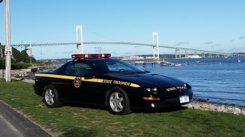 1991 Ford LTD Crown Victoria - State Trooper car parked near a bridge and the water.