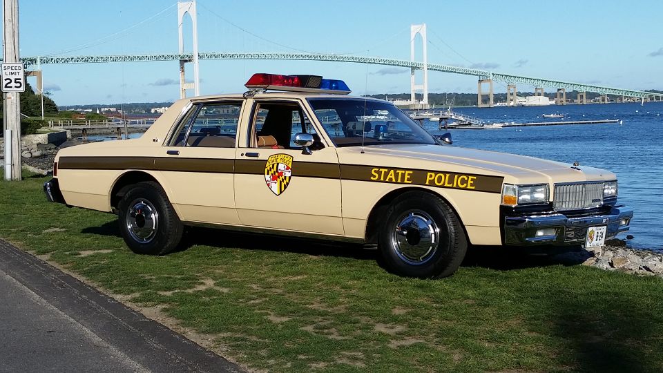Maryland State Police car parked by the water with a bridge in the background