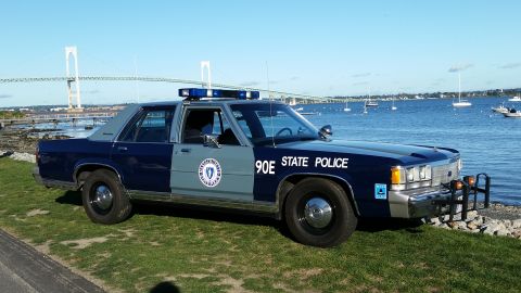 1991 Ford LTD Crown Victoria - A 1991 Ford Crown Victoria police car is parked near the water with a bridge in the background.