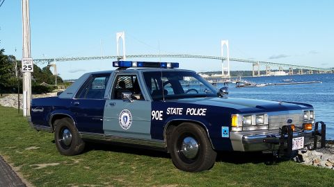 1991 Ford LTD Crown Victoria - A 1991 Ford Crown Victoria police car is parked near a body of water with a bridge in the distance.
