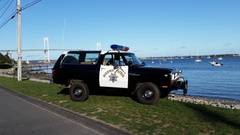 1991 Ford LTD Crown Victoria - This Dodge Ramcharger is marked as Highway Patrol and is parked near a body of water with a bridge visible.