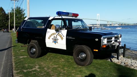1991 Ford LTD Crown Victoria - This Dodge Ramcharger is equipped as a police vehicle, seen near a bridge and the ocean.