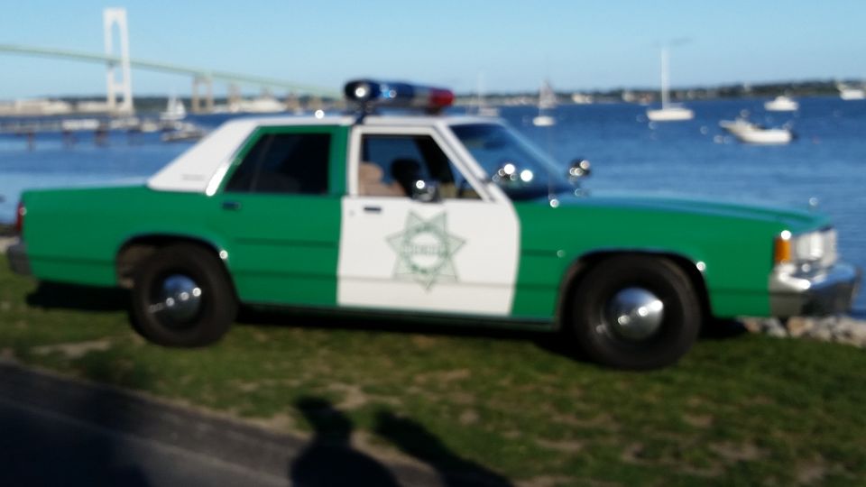 Blurry photo of a green and white sheriff police car by the water
