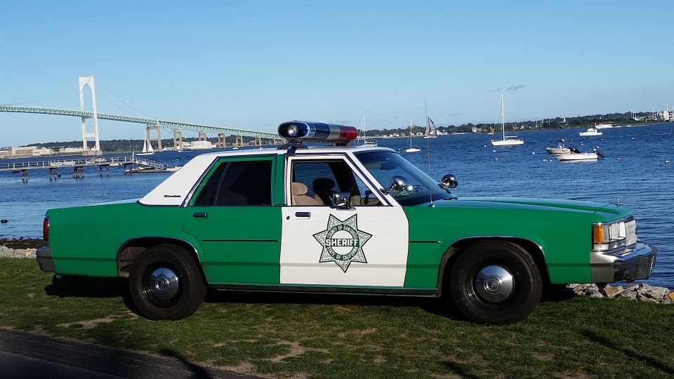 Green and white sheriff Ford Crown Victoria, side view by the water