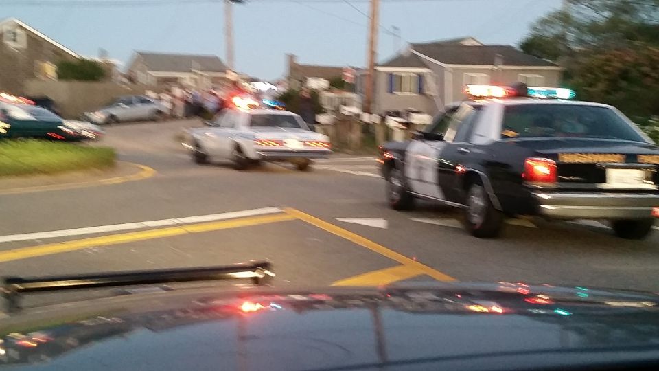 Highway Patrol and police cars at a coastal intersection at dusk