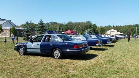 1991 Ford LTD Crown Victoria - Photo of Massachusetts State Police Ford Crown Victoria cruisers lined up on a grassy field at a car show.