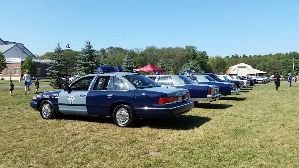 State Police cruisers lined up on a field at a car show