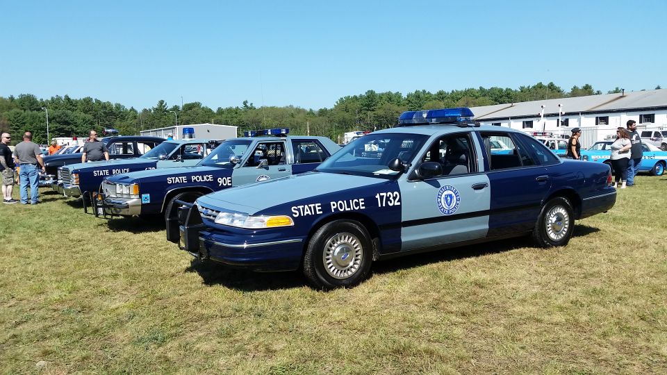 Row of Massachusetts State Police Ford cruisers at a car show