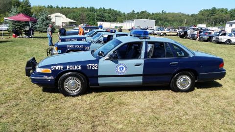 1991 Ford LTD Crown Victoria - A two-tone blue and light blue Massachusetts State Police Ford Crown Victoria sedan is parked on a grassy field with other vehicles in the…