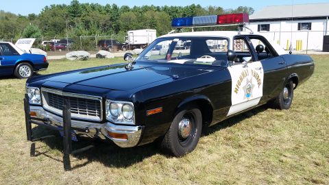 1991 Ford LTD Crown Victoria - A black and white police car with "HIGHWAY PATROL" text on the door is parked on grass, with another vehicle visible in the background.
