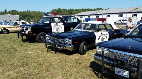 1991 Ford LTD Crown Victoria - Several vintage police cars are displayed outdoors on a sunny day.