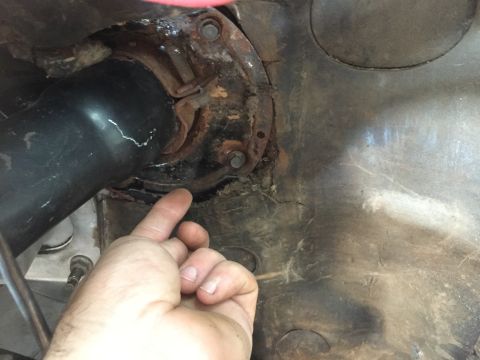 1986 Ford Bronco - A hand points to a cracked steering column mount, indicating a potential issue with the vehicle's steering system.
