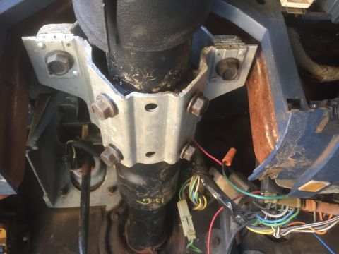 1986 Ford Bronco - Close-up of a vehicle's steering column bracket and exposed wiring.