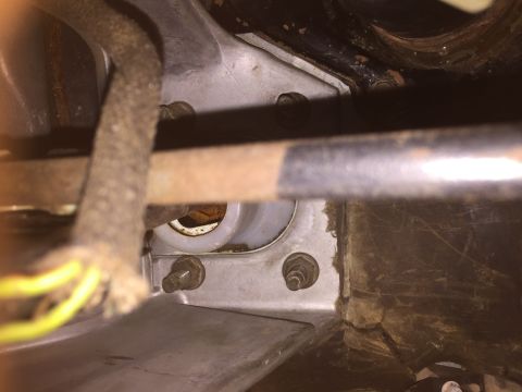 1986 Ford Bronco - This photo shows a close-up view of mechanical components and wiring under a vehicle, likely part of the drivetrain or suspension system.