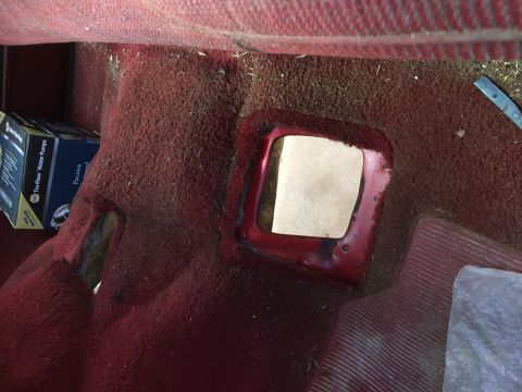1986 Ford Bronco - The interior floor shows a cutout in the red carpet, revealing the metal base and a piece of cardboard.