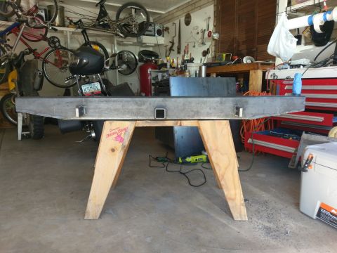 1988 Ford Bronco - A fabricated metal bumper with a hitch receiver sits on sawhorses in a cluttered garage.