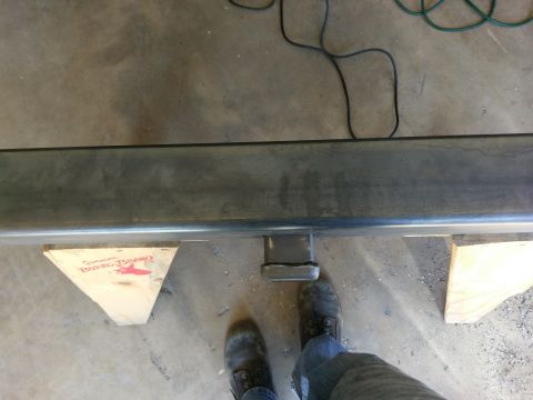 1988 Ford Bronco - Close-up of a metal bumper with a hitch receiver, supported by wooden blocks.
