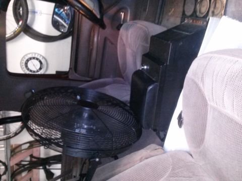 1996 Ford Bronco - Interior view of a vehicle, a large black fan and a center console, with seats visible.