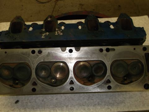 1971 Ford Ranchero - Close-up view of two engine cylinder heads, one painted blue and the other bare metal, showing intake and exhaust valves.