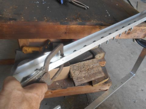 1992 Ford Bronco - A hand clamps an aluminum channel while holes are drilled into it, likely for a custom part.
