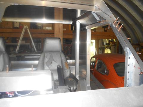 1992 Ford Bronco - An orange Volkswagen Beetle is visible in the background of a workshop, partially obscured by construction.