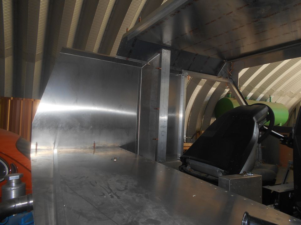 Interior view of custom metal fabrication inside a vehicle, showing a seat and dashboard area