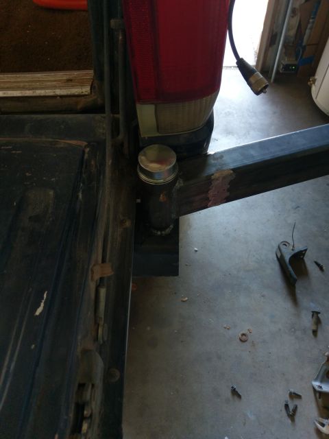 1988 Ford Bronco - Close-up of a trailer hitch receiver assembly, showing metalwork and a vehicle's taillight.