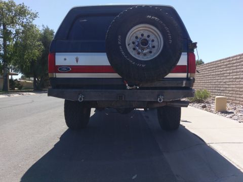 1988 Ford Bronco - Rear view of a 1988 Ford Bronco showing the spare tire and custom bumper.