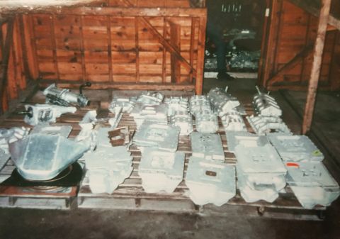1973 Ford Mustang - Multiple engine blocks and parts are organized on wooden pallets, likely in a storage or manufacturing facility.