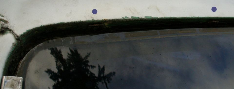 Windshield header trim removal. Purple dots show where the metal clips are hiding in the shadows. They snap onto little round tabs on the roof.