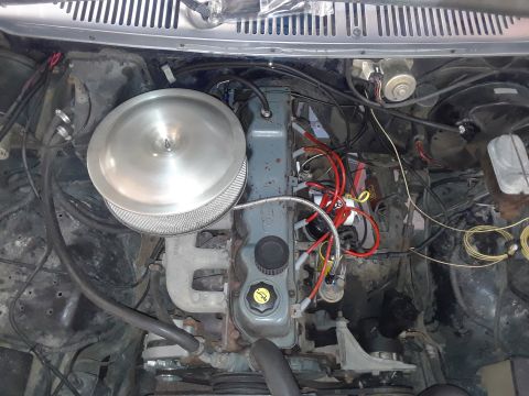 1985 Ford Bronco - The engine bay of a vehicle is shown with various components and wiring.