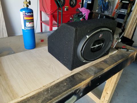 1994 Ford Bronco - A car stereo speaker sits on a workbench, with a propane tank nearby.