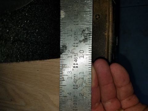 1994 Ford Bronco - A metal ruler is used to measure an object, showing markings up to 14 inches.
