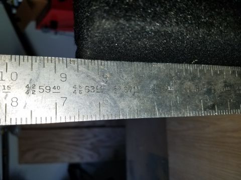 1994 Ford Bronco - A metal ruler with various markings is shown measuring a black textured object.