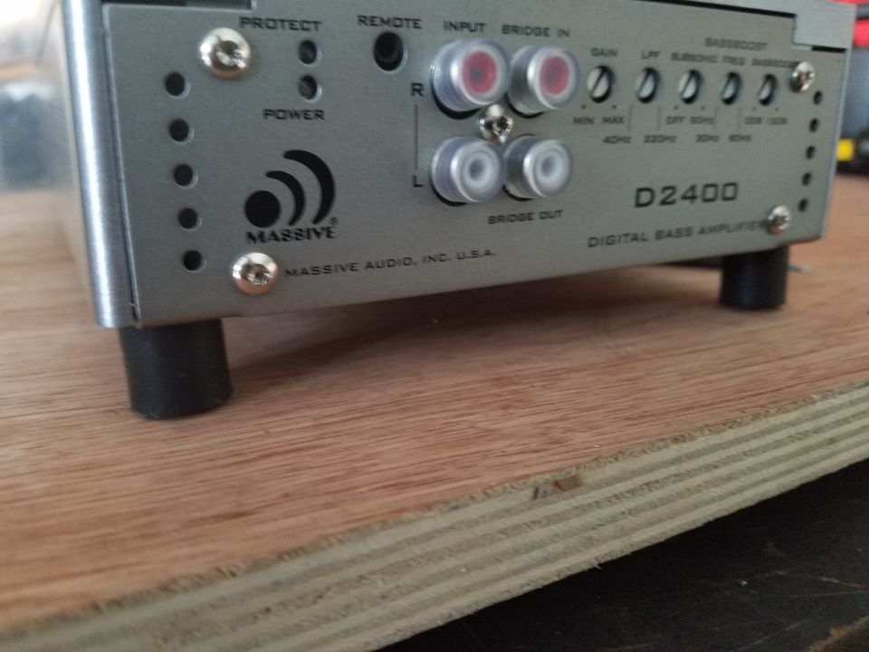 Silver car stereo amplifier with "MASSIVE AUDIO" logo and "D2400 DIGITAL BASS AMPLIFIER" text