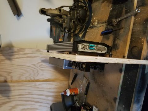 1994 Ford Bronco - A car stereo amplifier is mounted on a wooden shelf, with tools and other equipment in the background.
