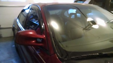 2002 Pontiac Grand Prix - The front passenger side of a red sedan is visible, parked indoors with the garage door open.